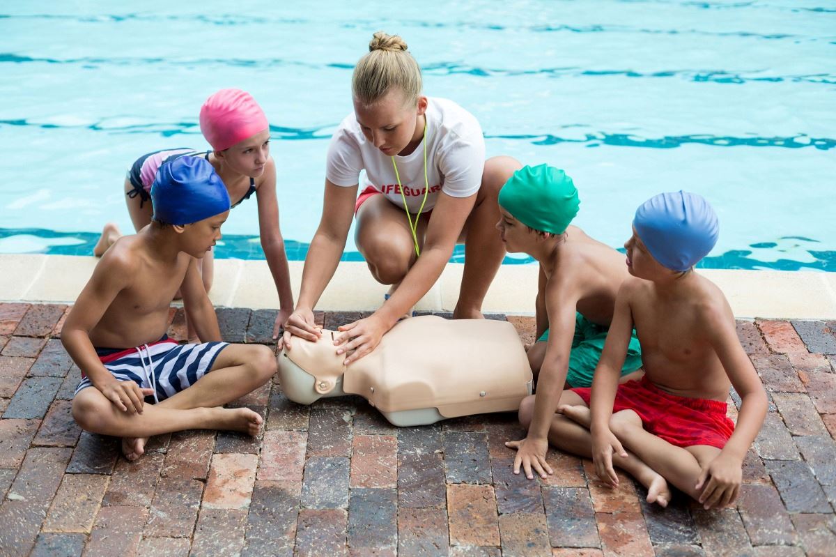 Photo of lifeguard teaching others how to perform CPR