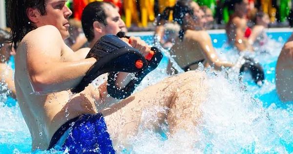 Photo of adults doing water resistance training by kicking and punching in water.
