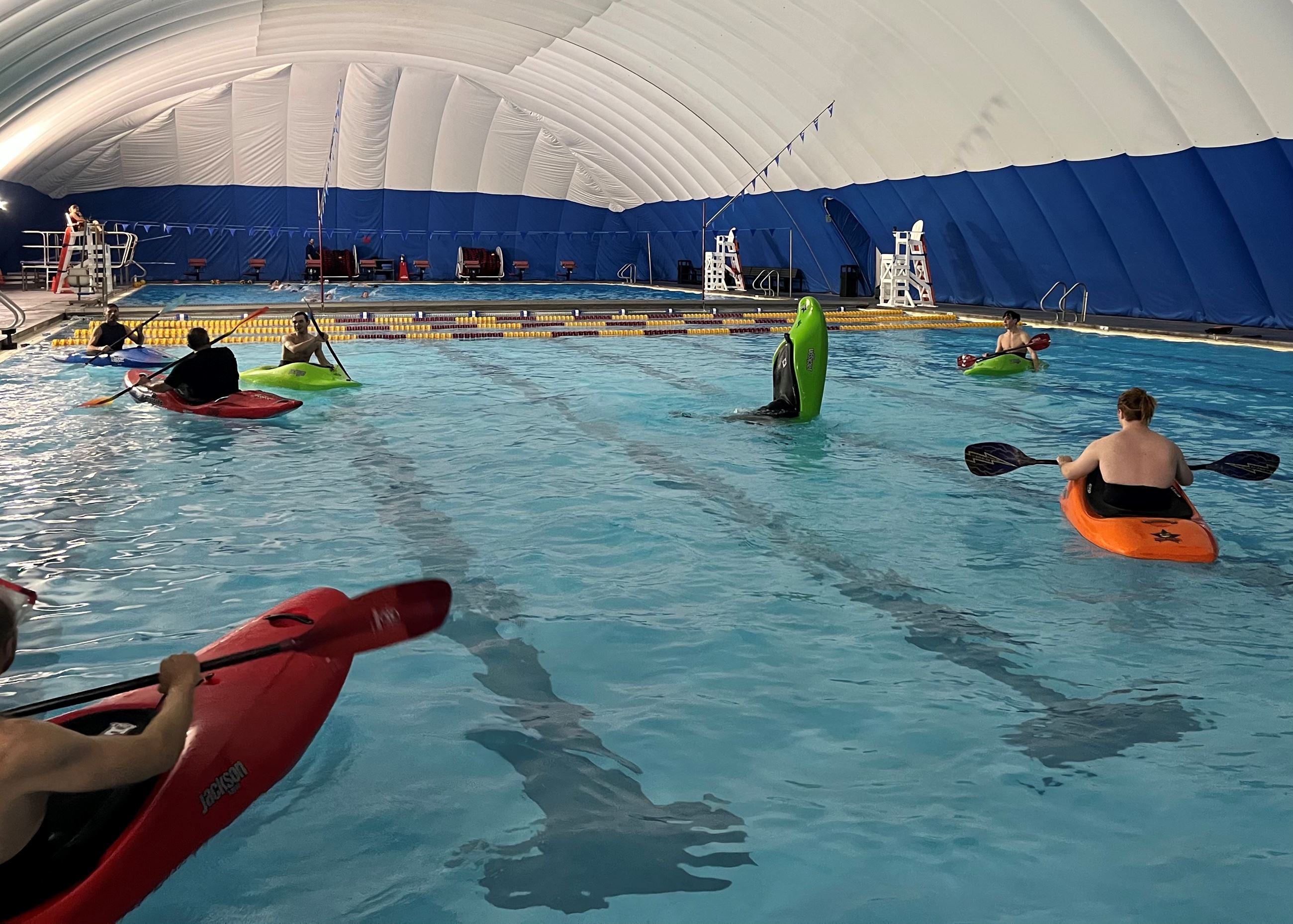 Photo of the water in the pool with people swimming.